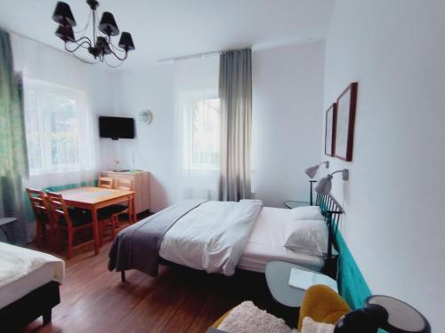 a bedroom with a bed and a desk and a table at u Bozeny pokoje in Dźwirzyno