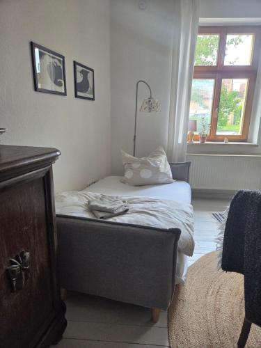 a small bedroom with a bed and a window at Apartment 1 im Martinsgarten Angermünde in Angermünde