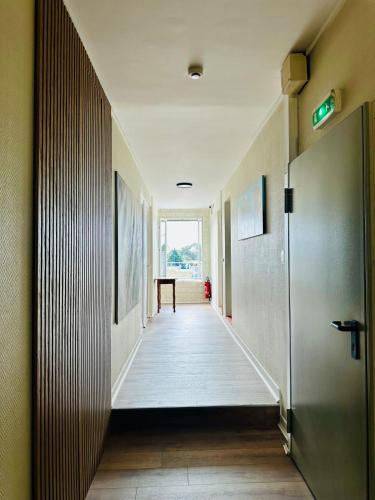 an empty hallway with a door and a table at Hotêl - Restaurant Le Bon Duc in Les Billaux