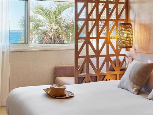 a hotel room with a bed with a hat on it at Mercure Saint Raphael Centre Plage in Saint-Raphaël