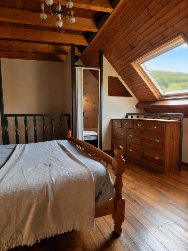 a bedroom with a bed and a large window at Duplex le Grimpeur - Les Apparts du Sancy in Chastreix
