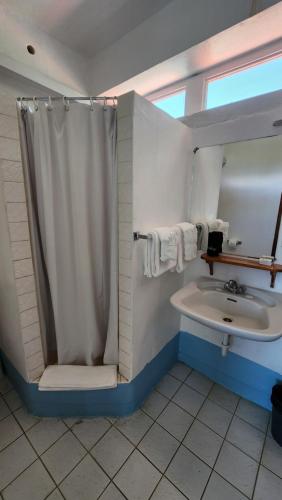 a bathroom with a shower and a sink at OE at Anchorage Hotel in Roseau