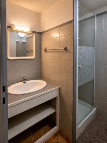 a bathroom with a sink and a shower at Duplex le Grimpeur - Les Apparts du Sancy in Chastreix
