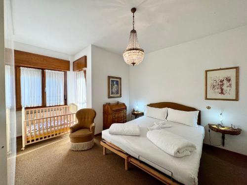 a bedroom with a bed and a chair and a chandelier at 1Dest - Garda Vintage in Arco