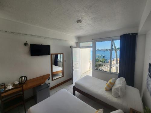 a hotel room with a view of the ocean at OE at Anchorage Hotel in Roseau