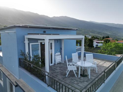 a balcony with a table and chairs on a blue house at La casa del pintor in Breña Alta