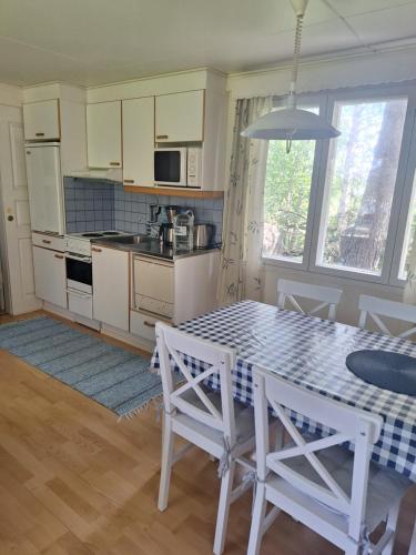 a kitchen with a table and some chairs and a table and a kitchen at Aijas Semesterstugor in Vaasa
