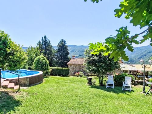 a garden with a swimming pool and two chairs at Holiday Home Luce by Interhome in Dicomano