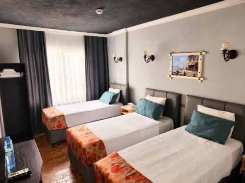 a hotel room with two beds and a mirror at City Park Suites City Center Corlu in Çorlu