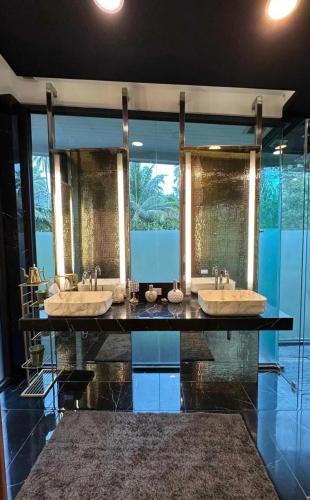 a bathroom with three sinks and a large mirror at Villa with the red pool in Hinkong