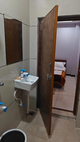 a bathroom with a sink and a shower and a toilet at Hotel Trilok in Ujjain