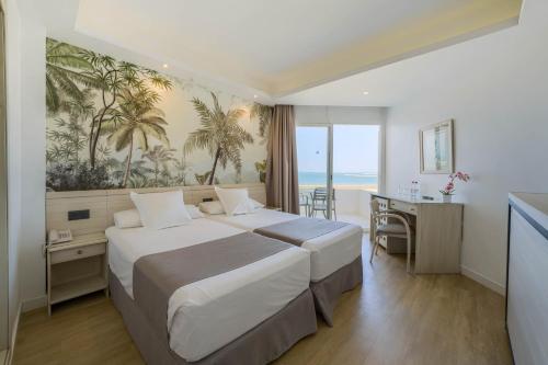 a hotel room with a large bed and a desk at Hotel Puerto Bahía & Spa in El Puerto de Santa María