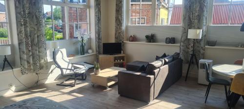 a living room with a couch and a table and windows at Panta Rhei - Logement de 12e stad in Berlikum