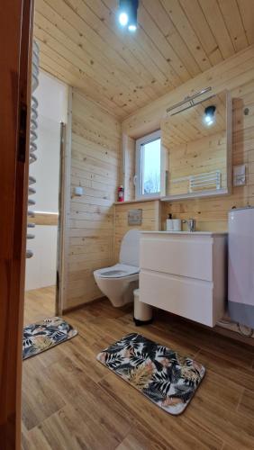 a wooden bathroom with a toilet and a sink at Fraseryja domek w Bieszczadach in Bukowiec