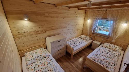 a room with two beds in a log cabin at Fraseryja domek w Bieszczadach in Bukowiec