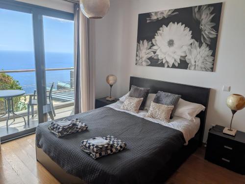 a bedroom with a bed with a view of the ocean at Loreto Luxury in Arco da Calheta