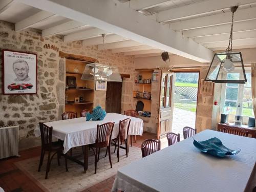 a dining room with a white table and chairs at Les Vergnes in Saint-Pardoux-le-Neuf