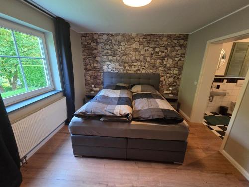 a bedroom with a bed and a stone wall at Ferienwohnung Talblick in Schmallenberg