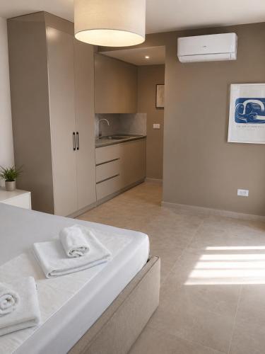 a bedroom with a white bed and a kitchen at White Arches in Ulcinj
