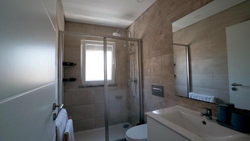 a bathroom with a shower and a toilet and a sink at Moradia T4 Fernão Ferro in Fernao Ferro