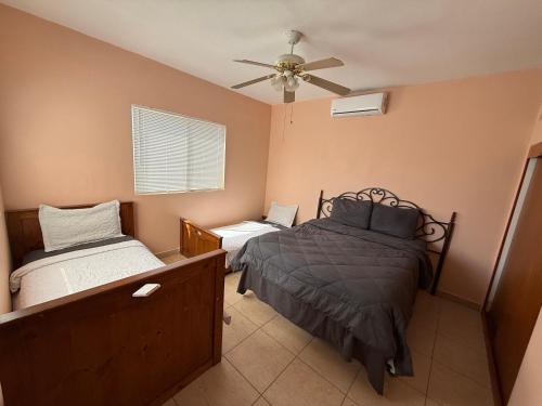 a bedroom with two beds and a ceiling fan at Bugambilias Terrazas in San Felipe