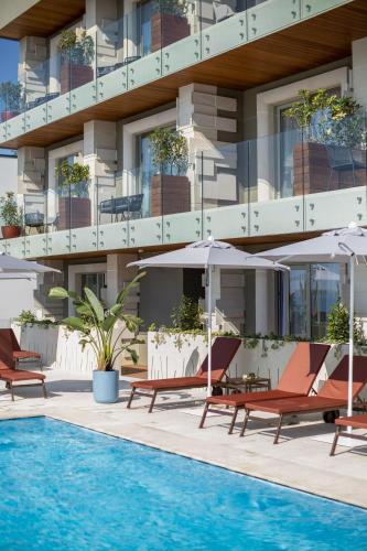 a hotel with a pool and chairs and umbrellas at Hotel Vlora Priam, Affiliated by Meliá in Vlorë