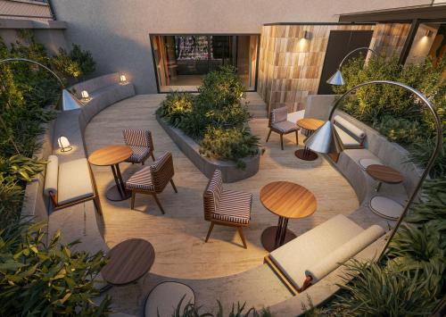 an outdoor patio with tables and chairs and plants at INNSiDE by Meliá Mexico Roma Norte in Mexico City