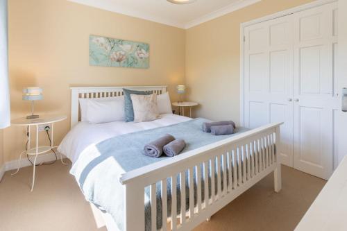 a bedroom with a white bed with two pillows on it at Saltkettle Sanctuary, Blakeney By Together Travel in Blakeney