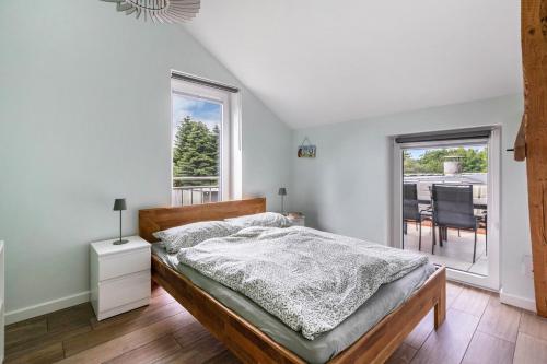 a bedroom with a bed and a balcony with a table at Hof Wuushöh in Stolk