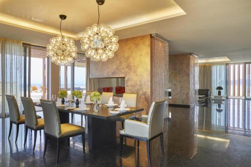 a dining room with a table and chairs and chandeliers at Adriatic Istria Resort by Minor Hotels in Savudrija