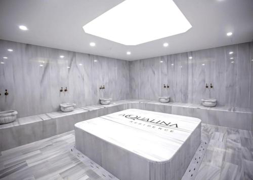 a bathroom with four sinks and a large white tub at Aqualina E4-1 by HolidayKeys in Kyrenia