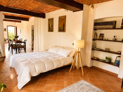 a bedroom with a bed in a room with a table at Country Loft Colle Miroteo in Monforte dʼAlba