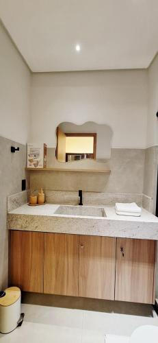 a bathroom with a sink and a mirror at Chale Praia Barrinha in Barrinha