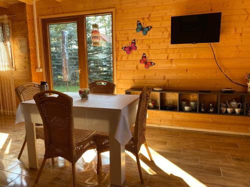 a dining room with a table with chairs and a television at Nela Martiany in Martiany
