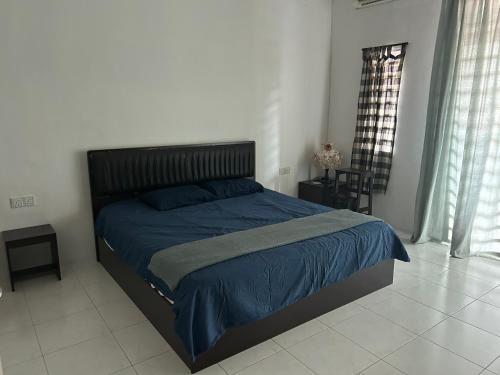 a bedroom with a bed with a blue comforter at Fairuz Homestay Ipoh in Ipoh
