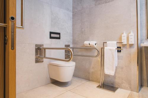 a bathroom with a toilet and a towel rack at Grand Hyatt Barcelona in Barcelona