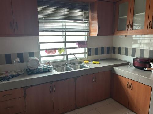 a kitchen with a sink and a window at Fairuz Homestay Ipoh in Ipoh