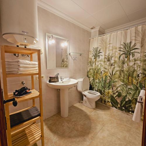 a bathroom with a sink and a toilet and a shower curtain at Cosy Apartament Figueres in Figueres