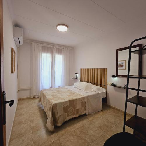 a bedroom with a bed and a window at Cosy Apartament Figueres in Figueres