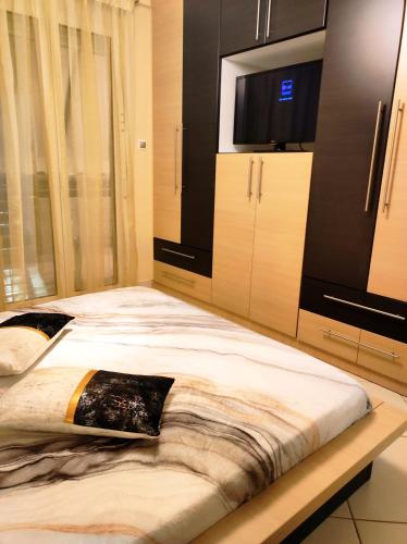 a bedroom with a large bed and a flat screen tv at CS apartment Patra in Patra