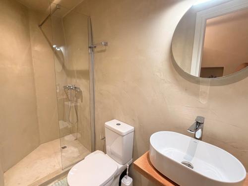 a bathroom with a toilet and a sink and a mirror at Luxe Lane Kalamoti in Chios