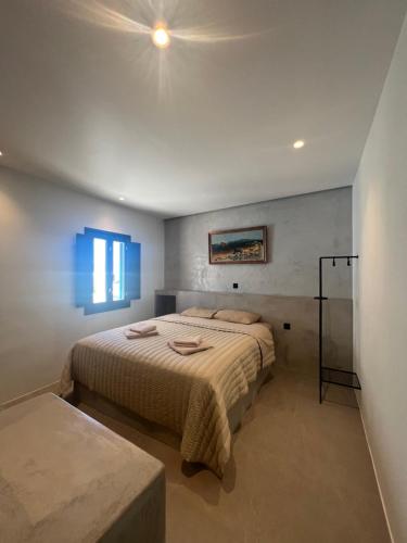 a bedroom with a king sized bed and a window at Iconic Project Lagada in Amorgos