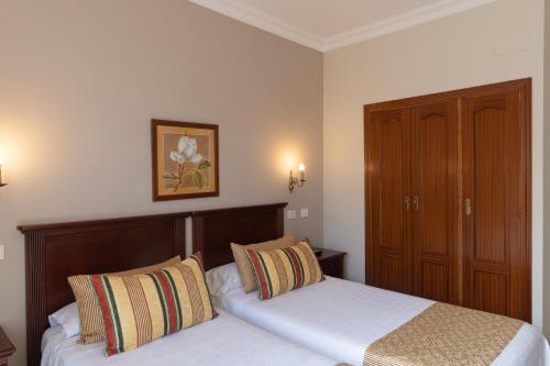 a bedroom with two beds and a cabinet at Hotiday Tenerife Norte in Puerto de la Cruz
