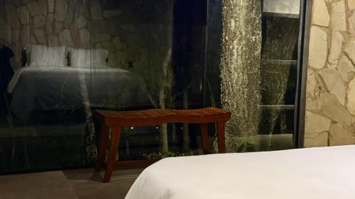 a bedroom with a bed and a table and a window at Exclusive Huts in Gravatá