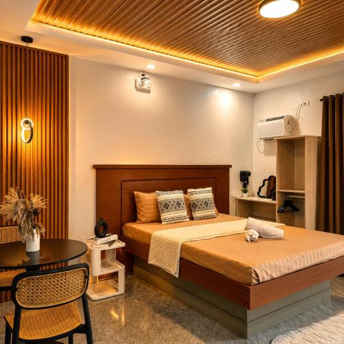 a hotel room with a bed and a table and a bed sidx sidx at K&M Studio Suites Casa KM in Bingag
