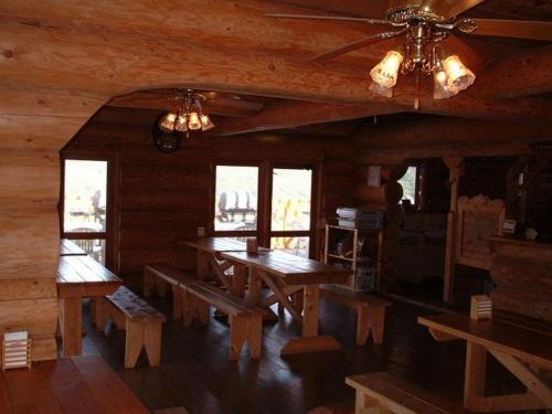 un comedor con mesas y bancos en una cabaña en Strawberry Farm Shirasaki, en Yura