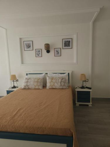 a bedroom with a bed with two night stands and two lamps at Huge oceanfront apartment in Tétouan