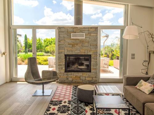 a living room with a stone fireplace and a chair at Villa Mulberry Garden by Interhome in San Marcello