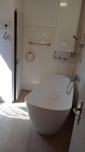 a white tub in a bathroom with a shower at Revans teázó apartman- belváros in Pápa