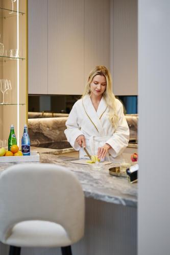 a woman in a kitchen preparing food on a counter at Apartamenty Topollino in Częstochowa